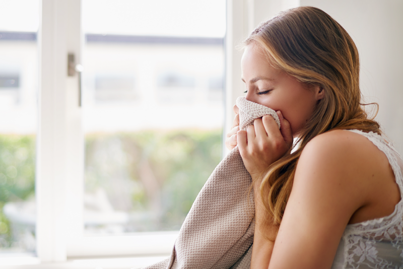 Como deixar a roupa cheirosa: imagem ilustrativa de mulher a cheirar roupa limpa e fresca.