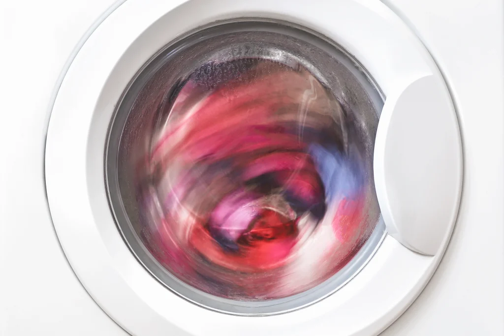 Máquina de lavar roupa durante a centrifugação, ilustrando o que é a centrifugação e como a rotação do tambor remove o excesso de água da roupa.